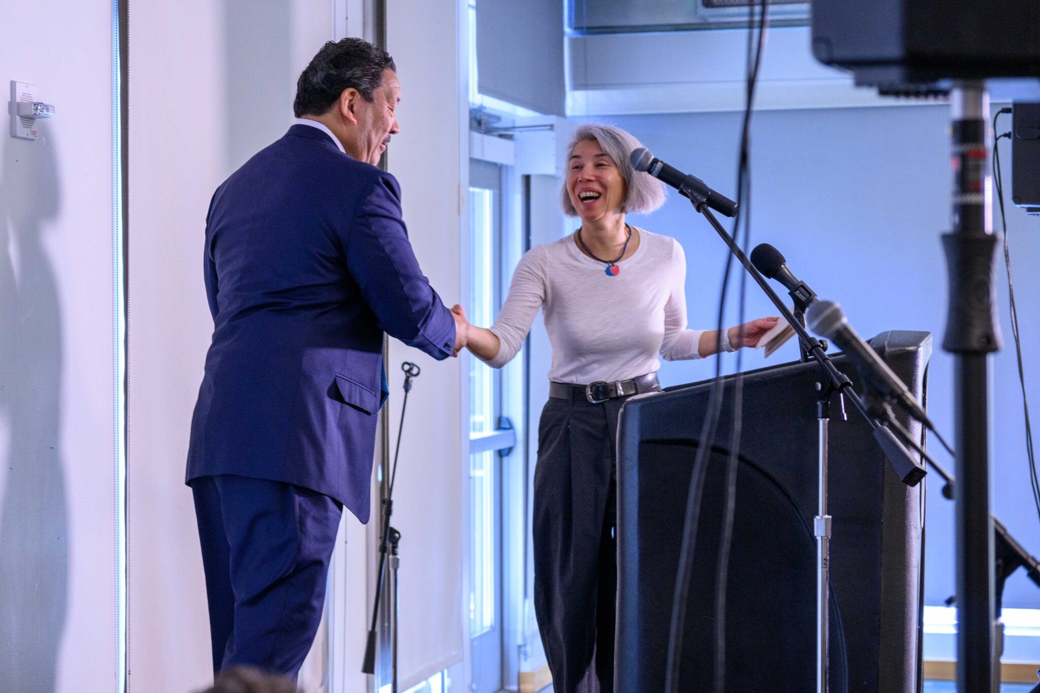 Maiko Winkler-Chin, Director, Seattle Office of Housing, shaking hands with Mayor Bruce Harrell onstage