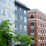 An apartment building facade with trees in front.