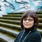 woman smiling with mural in background