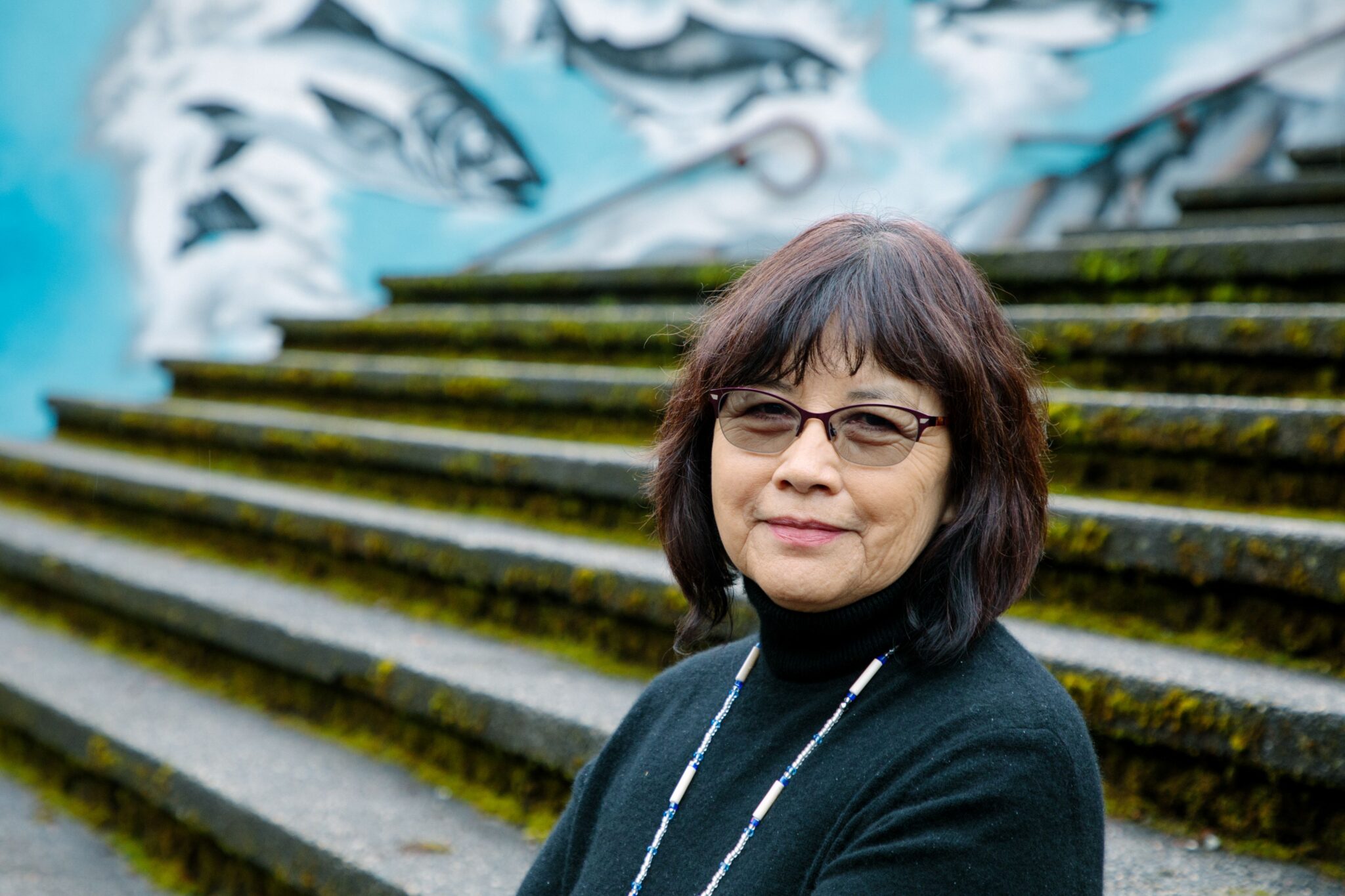 woman smiling with mural in background